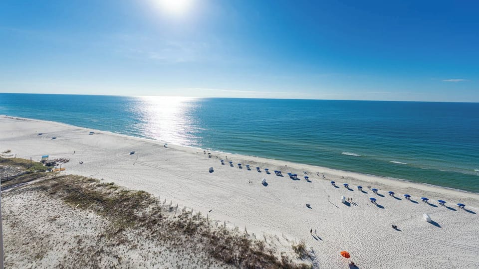 Take in the serene views of the sparkling water and beach, perfect for relaxation and outdoor activities