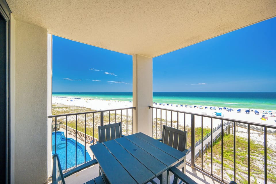 Blue skies stretch above your balcony where you relax watching waves lap the beach shore