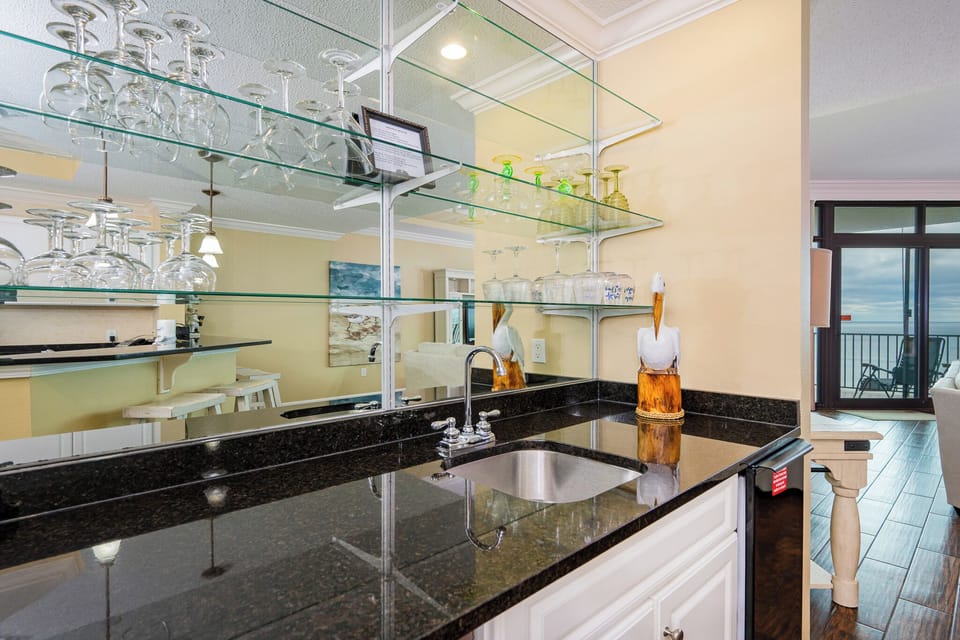 Unwind at the sleek wet bar, pouring your favorite drinks as you enjoy the soft glow of glassware