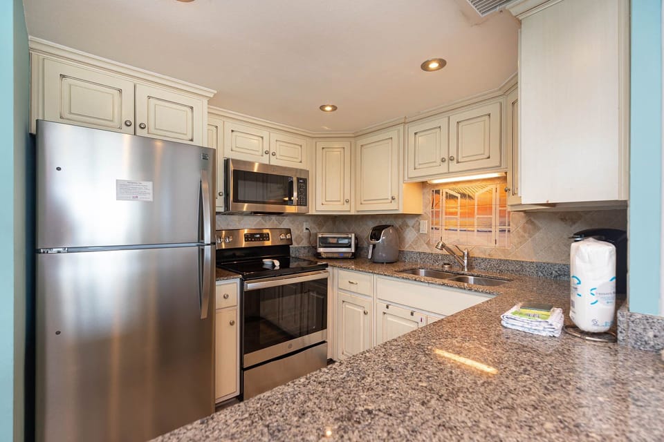 This kitchen features stainless appliances, granite countertops, and a cozy atmosphere perfect for preparing meals
