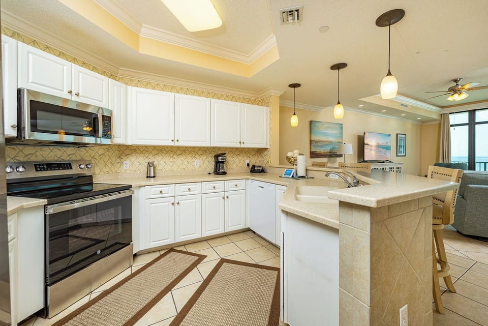 Smooth tile floors cushion your steps as you prepare meals and share stories at the breakfast bar in the kitchen