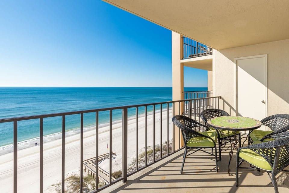 Enjoy the inviting balcony with a colorful table and chairs, perfect for soaking in the breathtaking beach views