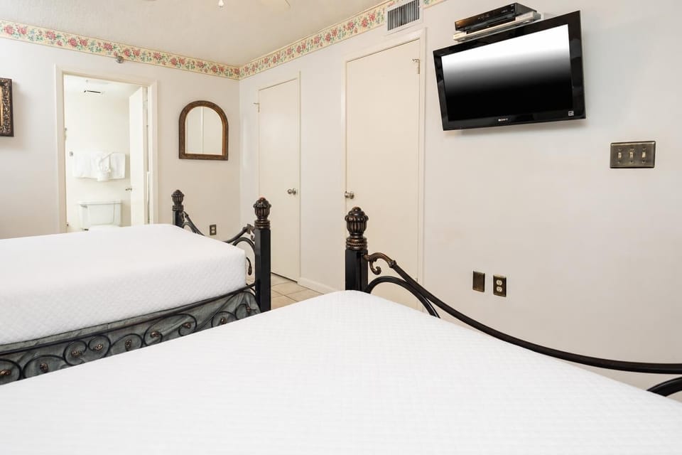 Relax in this inviting guest room with two queen beds, decorative accents, and a flat-screen TV