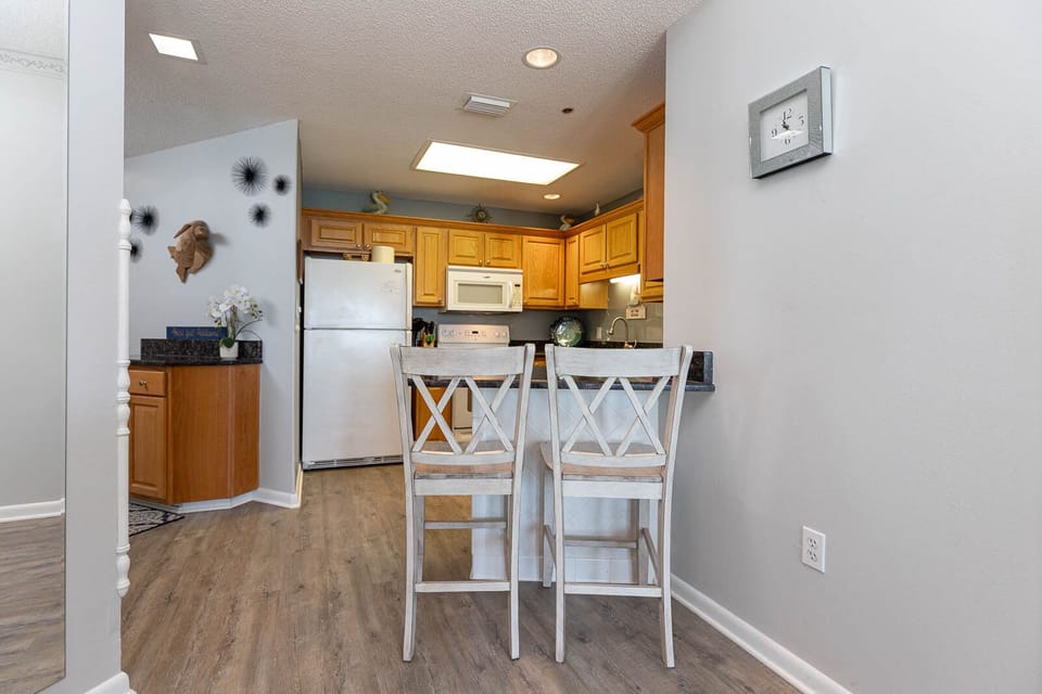 Gather around the breakfast bar with friends in this inviting kitchen featuring warm wooden cabinetry