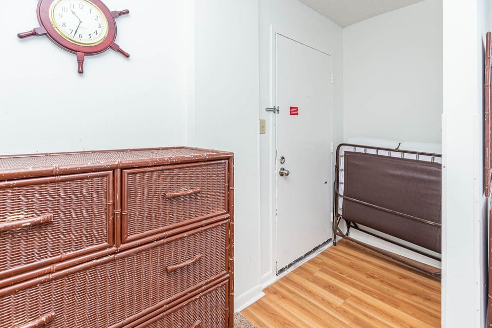 This entryway features a stylish dresser and a convenient foldable bed, perfect for additional guests