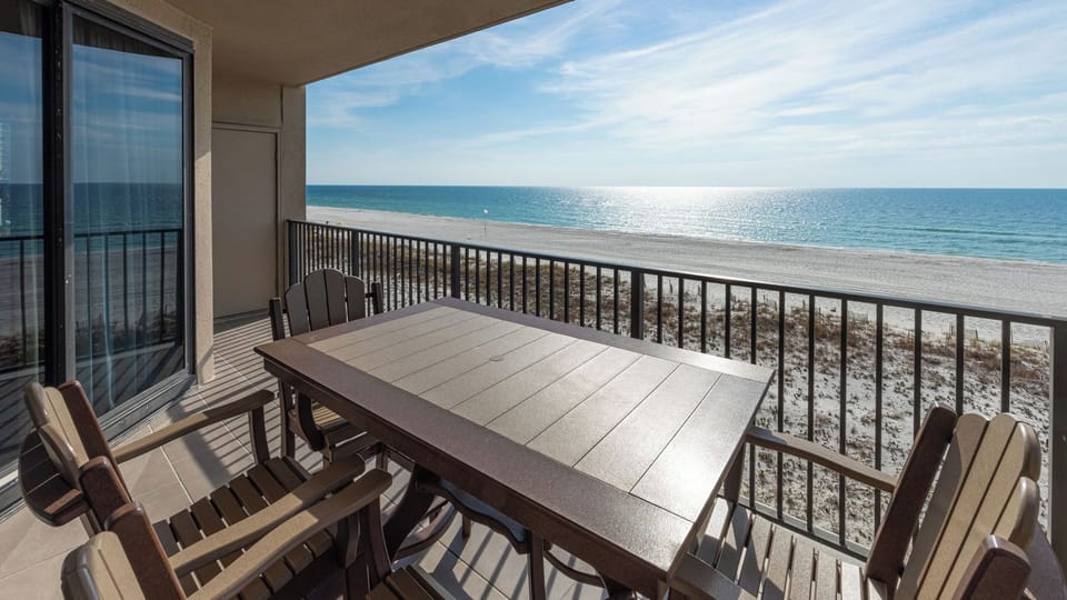 Dine at the outdoor table while enjoying the calming views of the water and beach from your comfortable seating
