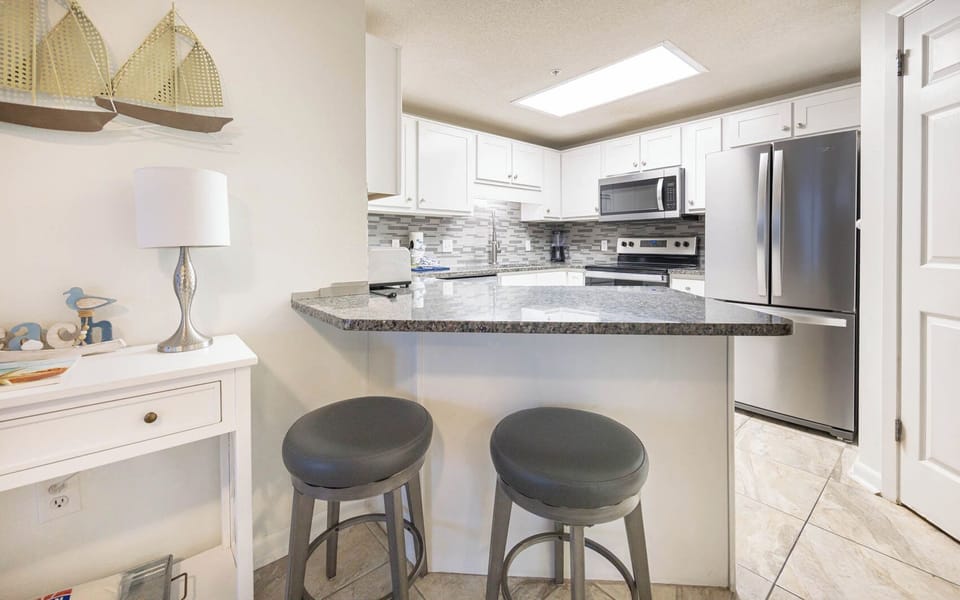 Gather at the sleek bar stools for a casual meal or drink while enjoying the inviting kitchen atmosphere