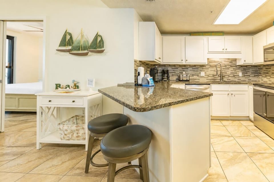 Smooth granite breakfast bar invites casual mornings filled with coffee aromas and quiet moments in the kitchen