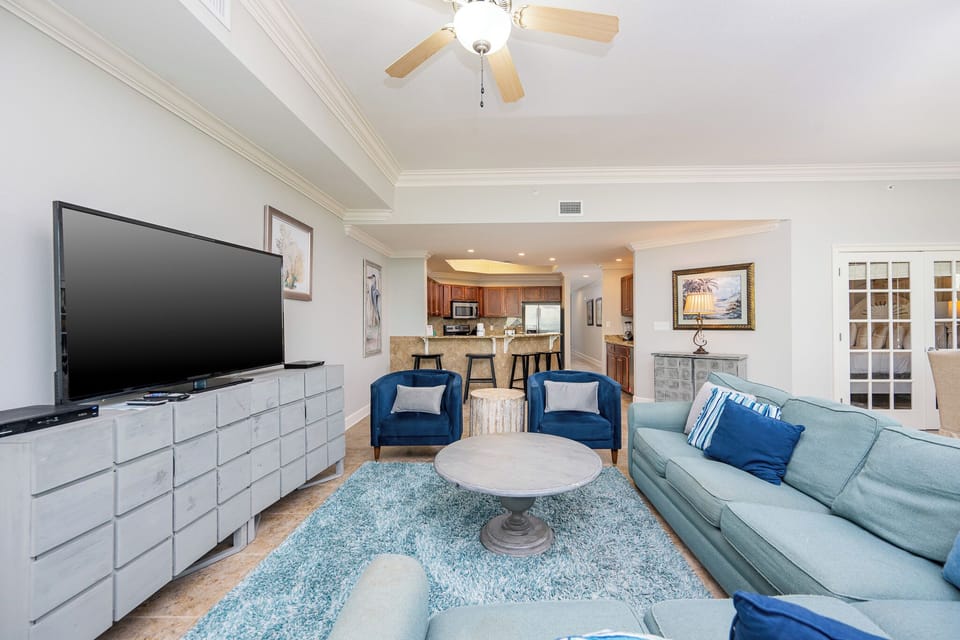 This living area features a large TV, comfortable seating, and a stylish rug, perfect for relaxing after a day at the beach