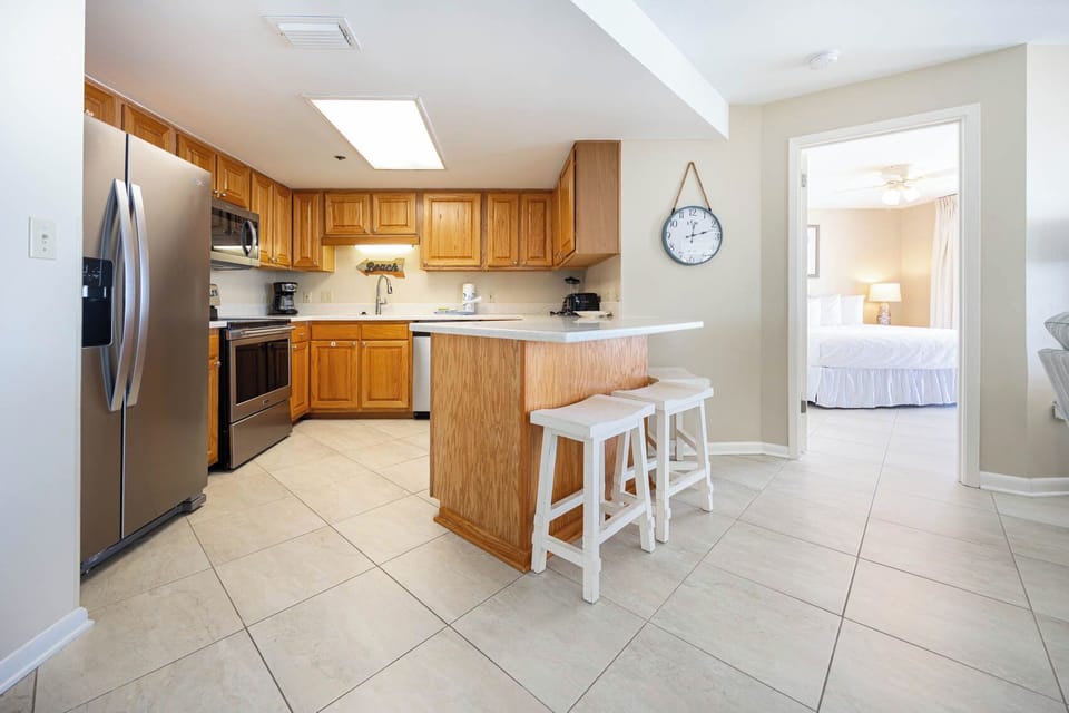 Prepare meals in the spacious kitchen, featuring wooden cabinetry and a convenient breakfast bar
