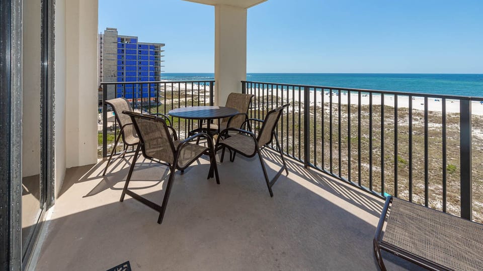 Balcony seating offers a serene view of the beach and turquoise waters, perfect for enjoying the coastal breeze