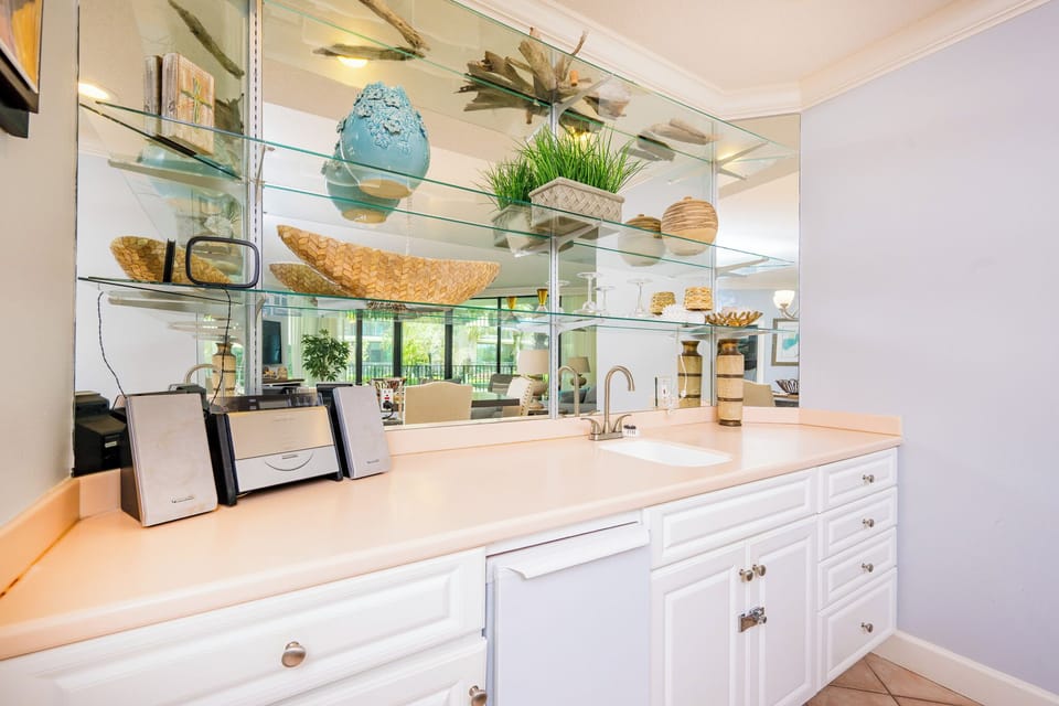 Enjoy refreshing drinks and good company at the charming wet bar, embracing a relaxed coastal vibe