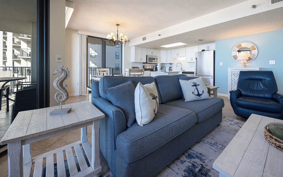 Unwind on the comfortable sofa adorned with nautical pillows, with easy access to the dining area and kitchen