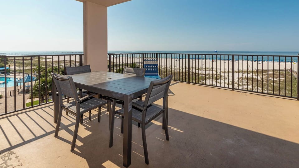 Enjoy meals on the spacious balcony with views of the beach and pool area just steps away