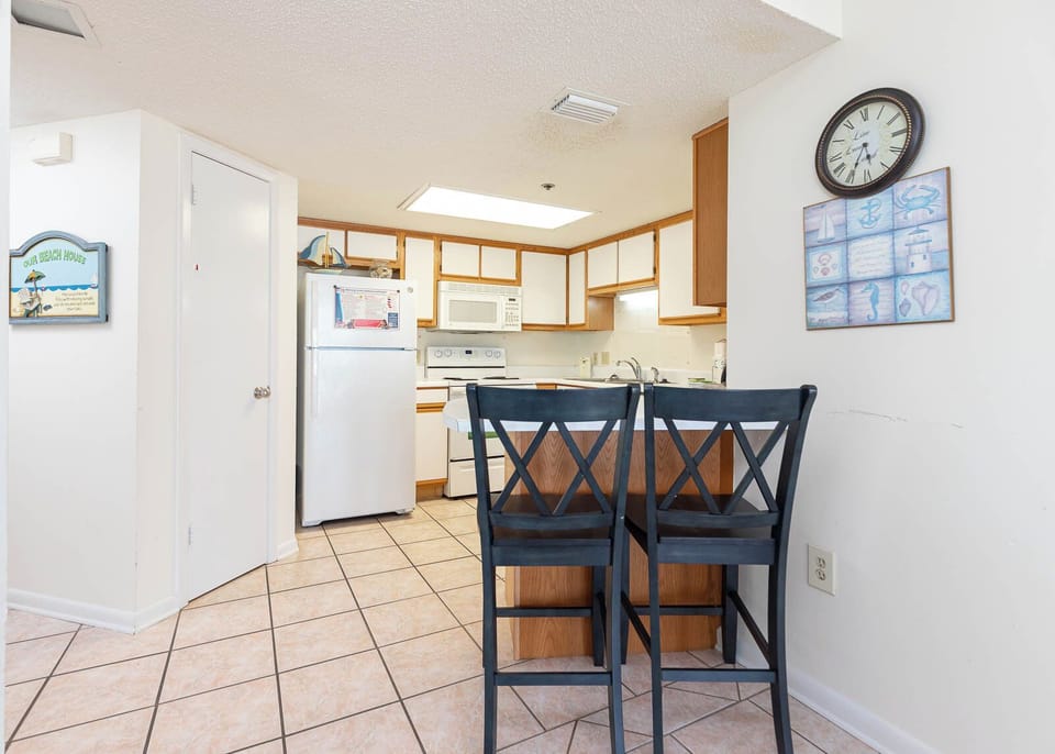 Gather at the bar, enjoying the open kitchen layout and coastal decor for a relaxed dining experience