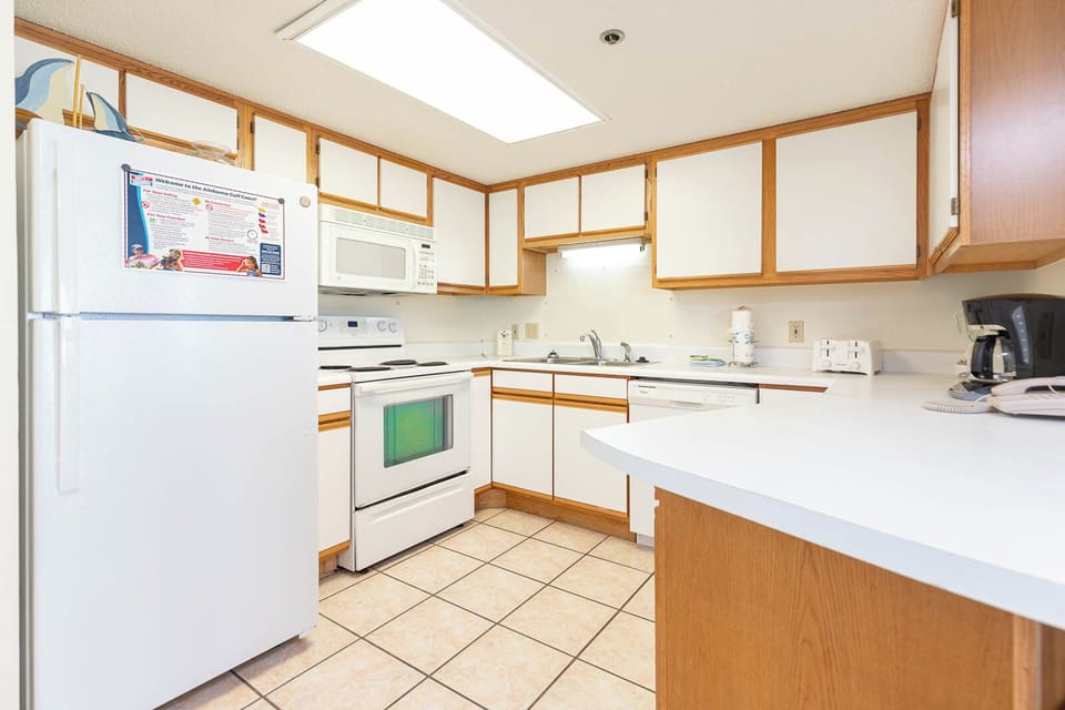 Prepare meals in the kitchen featuring ample counter space, white appliances, and a welcoming vibe