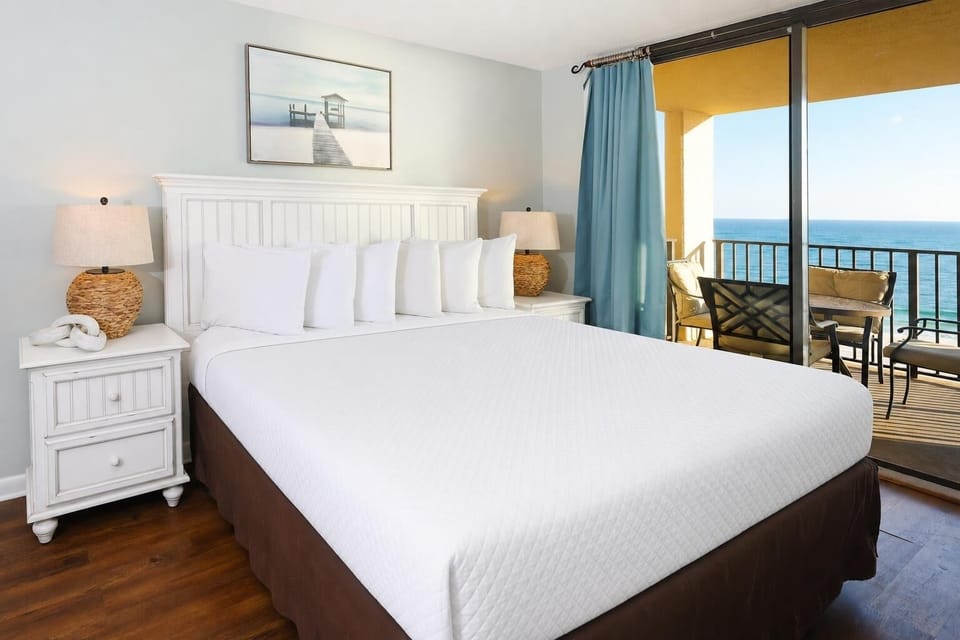 Experience restful nights in this inviting master bedroom with a king bed, stylish decor, and a beachfront view