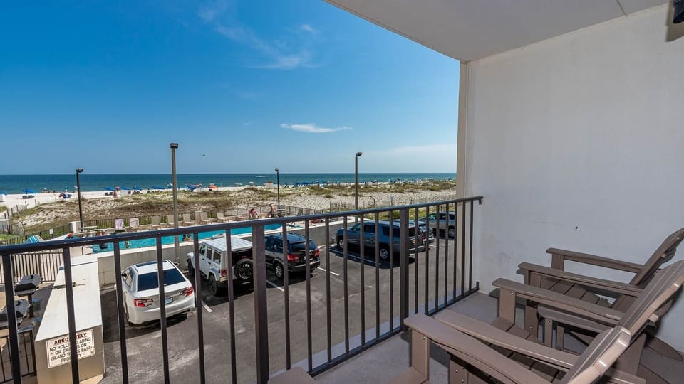 Enjoy a relaxing view from the balcony overlooking the beach and pool area, perfect for unwinding after a day of fun