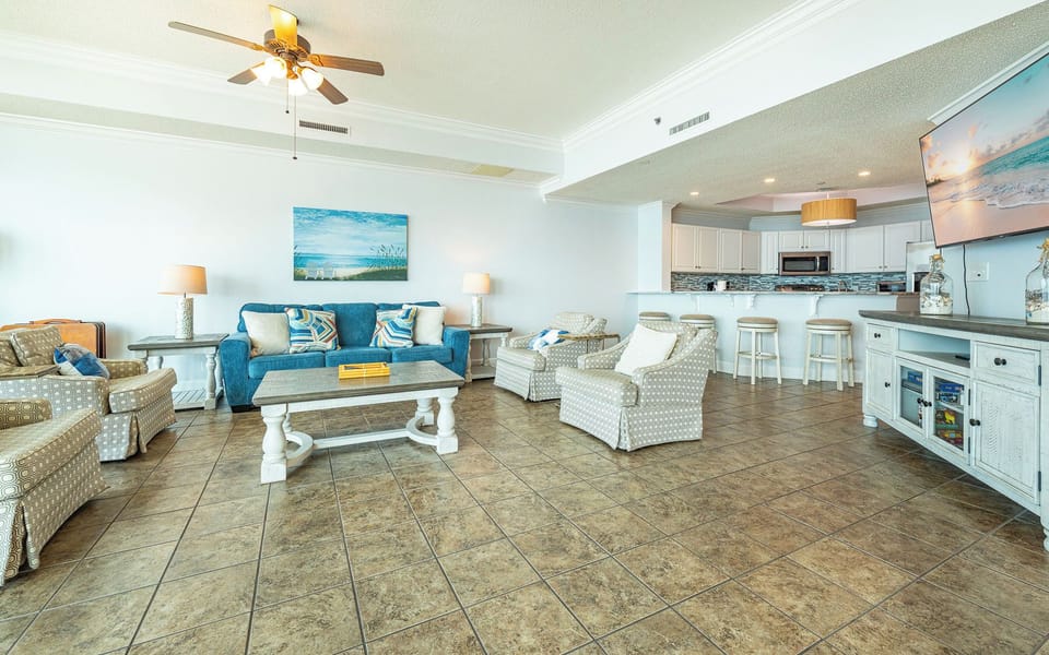 Relax in the spacious living area, surrounded by beach-inspired decor, perfect for family gatherings