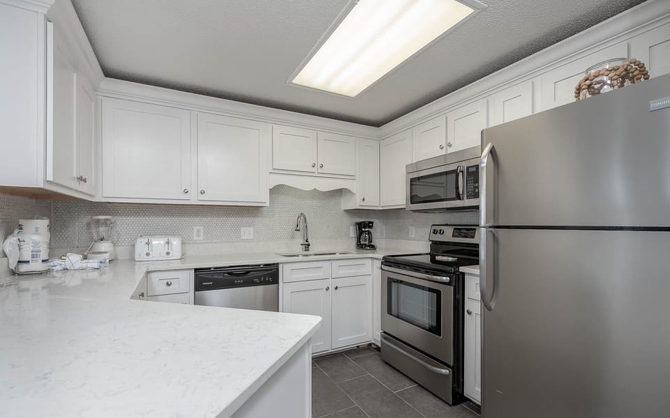 Prepare delicious meals in the sleek kitchen featuring stainless steel appliances and elegant countertops