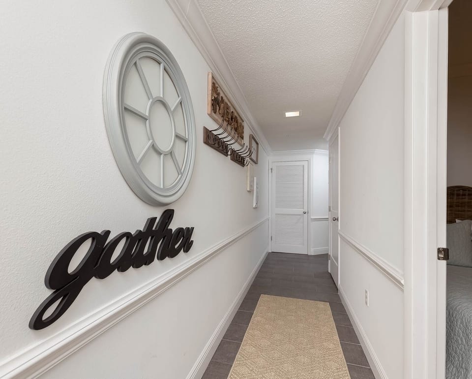 Step into a welcoming hallway adorned with charming decor, leading you to comfortable living spaces