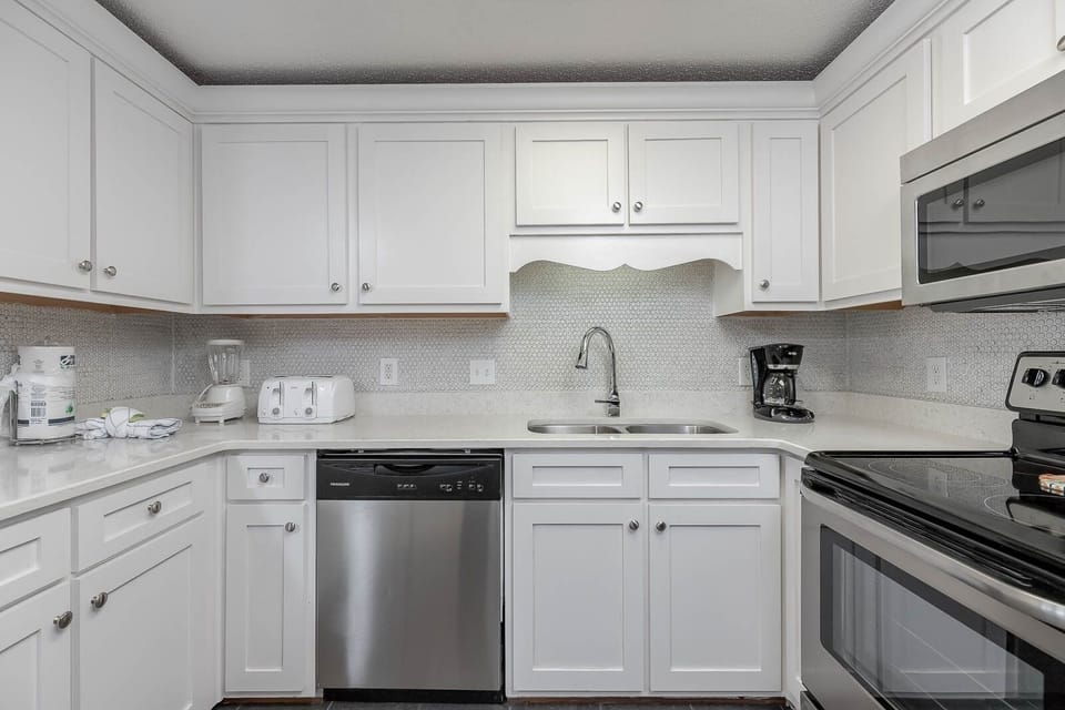 Cook and gather in the bright kitchen featuring sleek countertops and stainless steel appliances for your culinary delights