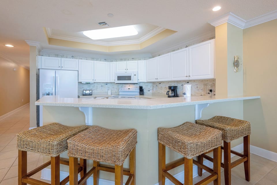 Enjoy casual conversations around the textured bar stools, creating lasting memories in the heart of this inviting kitchen