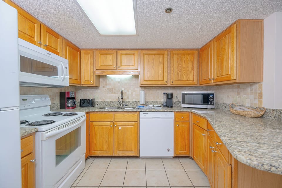 Gather around the breakfast bar, enjoying the warm wood tones and inviting kitchen atmosphere