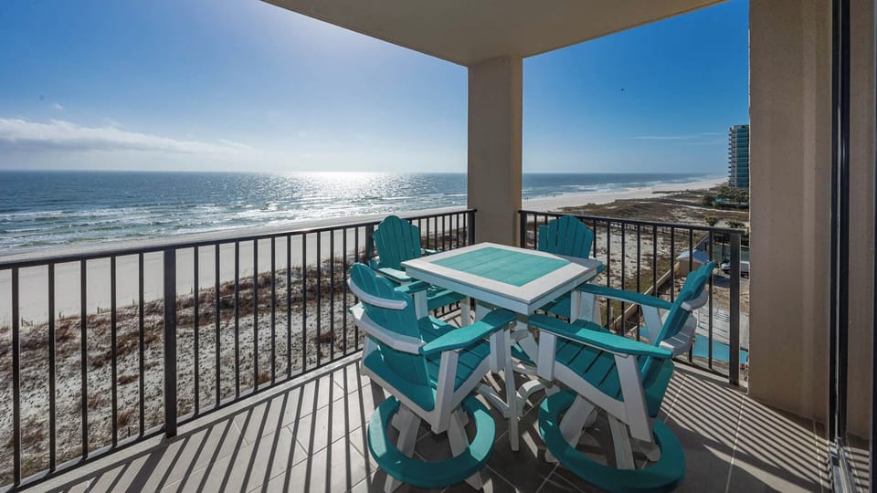 Enjoy meals or drinks at the turquoise table while taking in the expansive beach views from your balcony