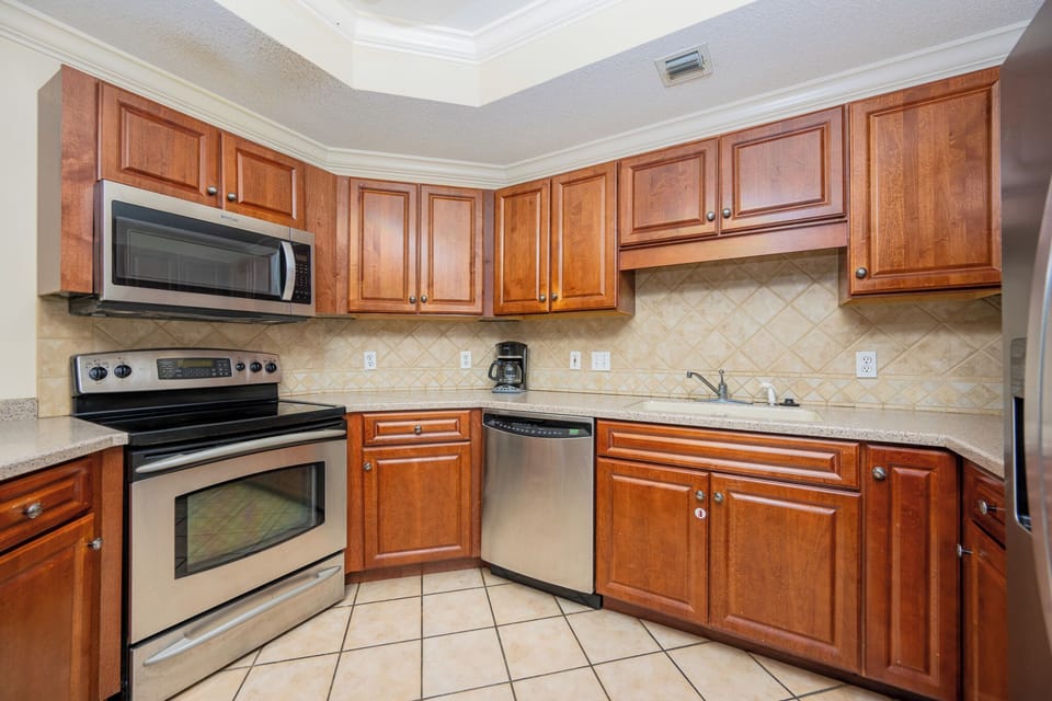 Prepare meals in this kitchen with elegant cabinetry, stainless appliances, and stylish backsplash