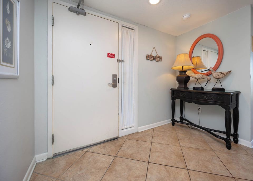 This welcoming entryway features a stylish black console table with decorative accents, setting a cheerful tone for your stay
