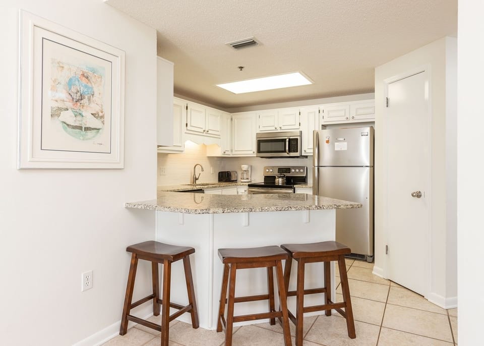 White cabinetry complements the granite countertops and stainless appliances in this inviting kitchen area
