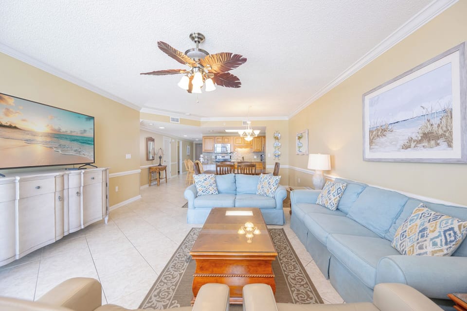 Unwind in the spacious living area, with a sofa with queen sleeper, coffee table, and a view of the dining space beyond