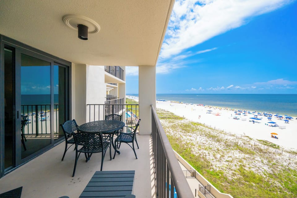 A stylish outdoor dining set overlooks the beach front, offering a perfect spot to enjoy the scenic coastal view