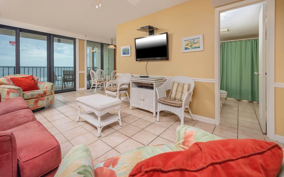 This living area features colorful tropical decor,queen sofa-sleeper, flat-screen TV, and a lovely view of the beach