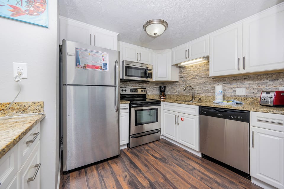 This kitchen features stainless steel appliances, granite countertops, and a welcoming atmosphere for meal preparation