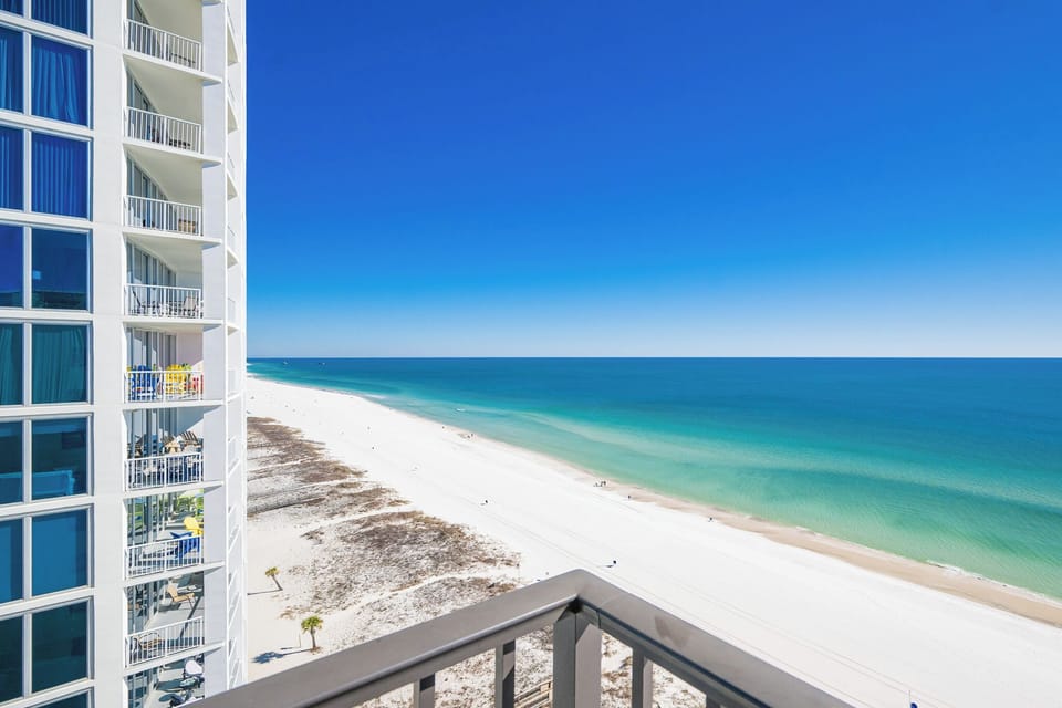 Enjoy stunning panoramic views from your corner balcony on the beach