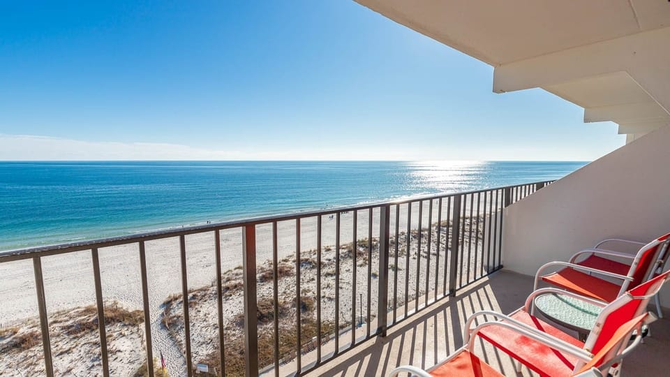 Enjoy breathtaking views from the balcony with comfortable seating overlooking the sandy beach and tranquil waters