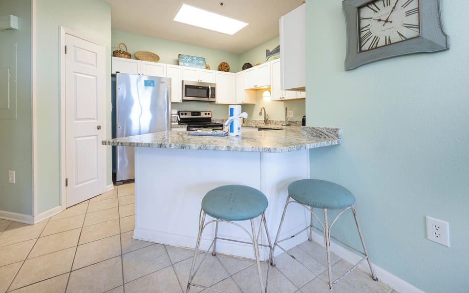Enjoy a casual chat at the kitchen bar, savoring the coastal vibe while preparing your favorite snacks