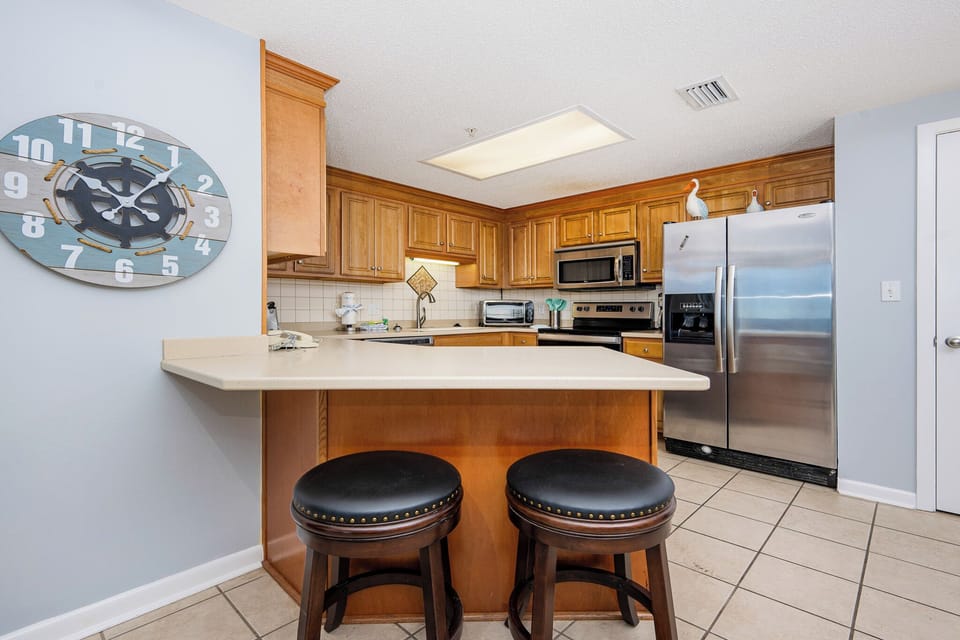 Prepare meals at the spacious kitchen, featuring stainless appliances and inviting seating for casual dining