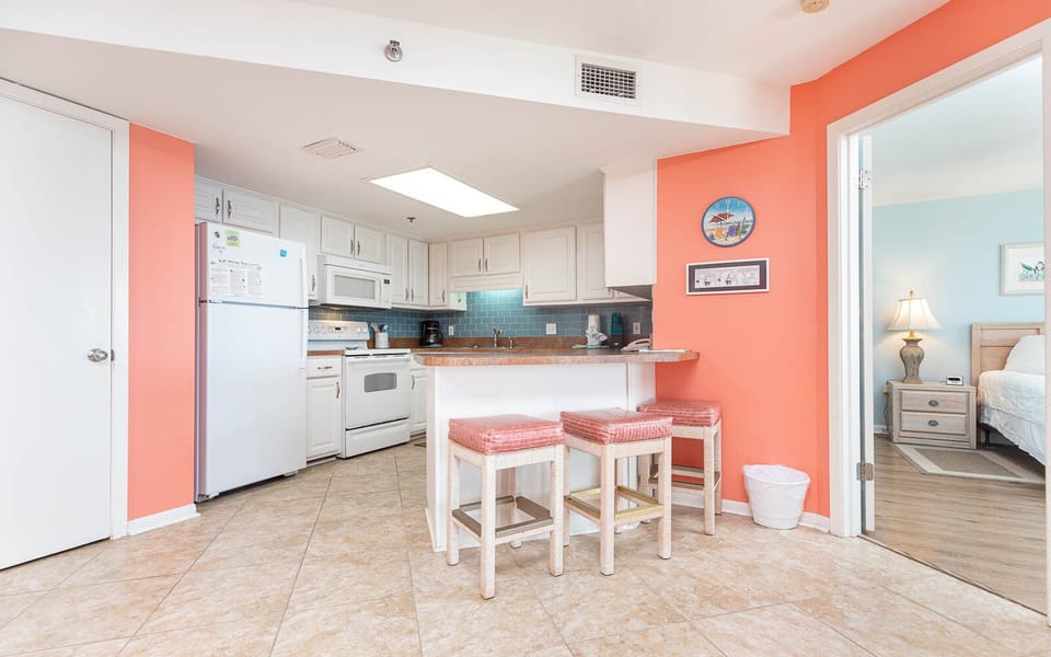 Brightly colored walls complement the kitchen with a breakfast bar and seating, leading to the master suite