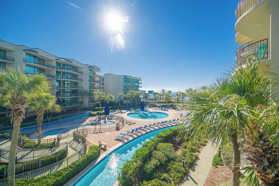 Relax on the balcony, soaking up sunlit views of the inviting pool area and lush surroundings