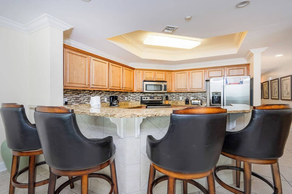 Kitchen featuring granite countertops, stainless appliances, and stylish bar seating for a cozy dining experience