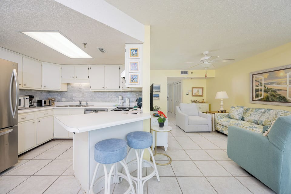 Soft yellow walls brighten your living room where you sink into cozy seating after a day on the coast