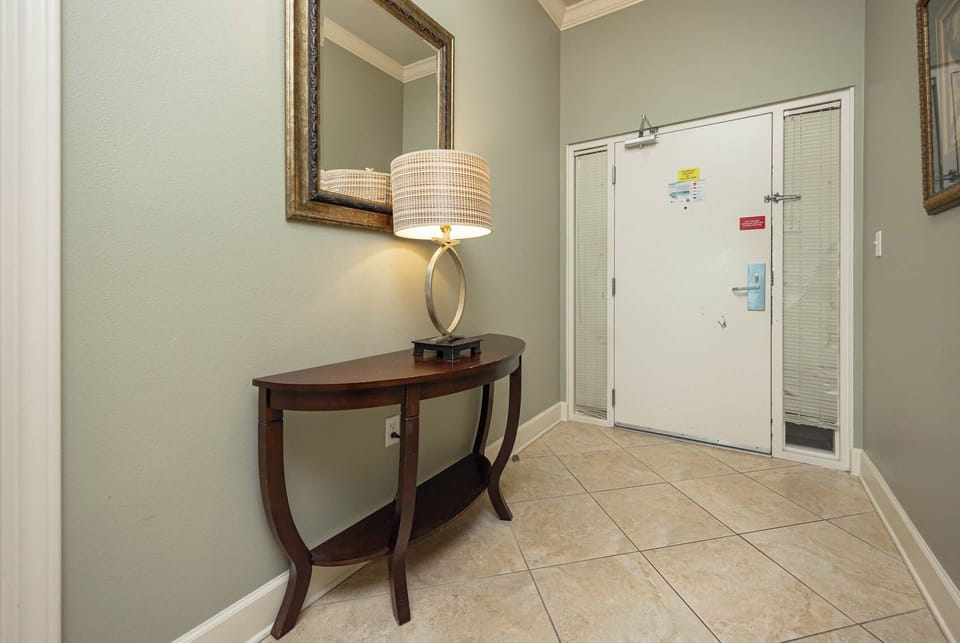 Step into a welcoming entryway with a stylish lamp and mirror that create a warm first impression as you arrive