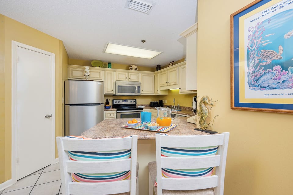 Enjoy breakfast at the bar with colorful decor, stainless appliances, and a warm, inviting atmosphere
