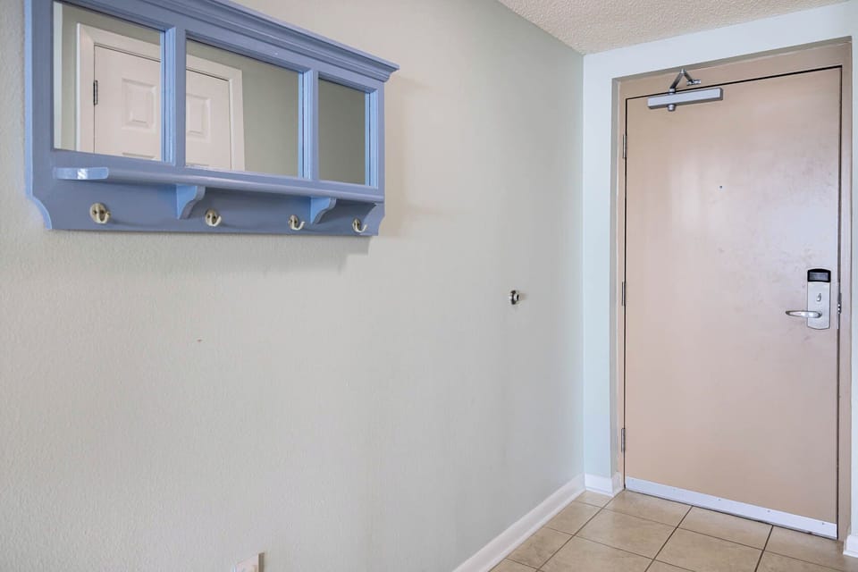 Step into a welcoming entryway featuring a blue coat rack and a mirror, perfect for a quick glance before heading out