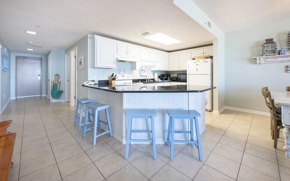 Gather around the spacious breakfast bar with seating, perfect for coffee and conversations during your stay