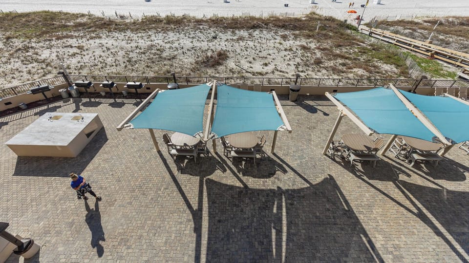 Gather around the shaded tables at the outdoor pool area, perfect for enjoying meals and relaxing in the warm sunshine