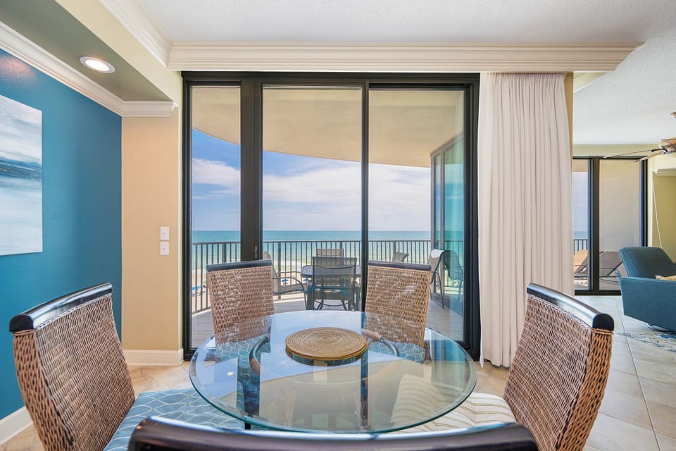 Enjoy meals at the round dining table, with views through large glass doors leading to a balcony